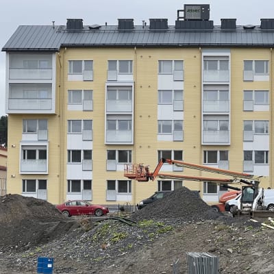Vastavalmistunut puukerrostalo edestäpäin kuvattuna Lahden entisen Nelon leipomon korttelissa, julkisivussa keltainen laudoitus.