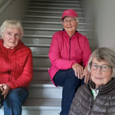 Tre damer sittandes i trappa