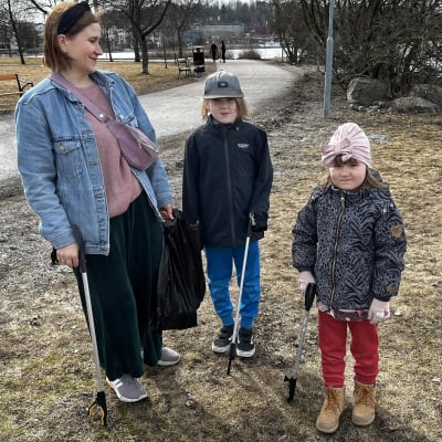 Aaltosen perhe äiti Neea-Reeta ja lapset Aappo ja Toini keräävät roskia Ankkurin alueen nurmikoilta, vieressä vielä jäässä oleva Vesijärvi.