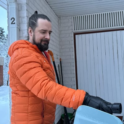 Hämeenlinnalainen Harri Kortesalo asettaa sähköauton pistoketta autoon.