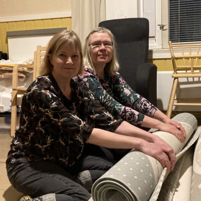 Hanne Miettinen ja Mari Piirainen rullaamassa mattoja säilytystä varten. 