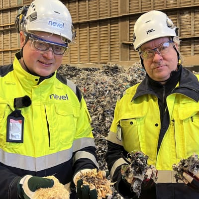 Energiayhtiö Nevelin kypärään ja huomiotakkiin pukeutuneet Clas Blomberg ja Petri Koivunen esittelevät purua, haketta ja SRF-polttoainetta.