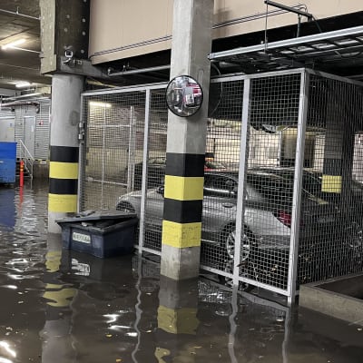 Autohallissa on autoja tulvaveden ympäröimänä.