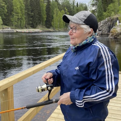 Nainen kalastaa laiturilla.