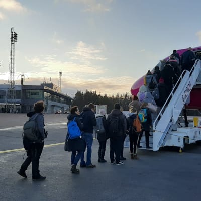 Passagerare stiger på ett av WizzAirs rosa-lilafärgade flygplan på Åbo flygplats.
