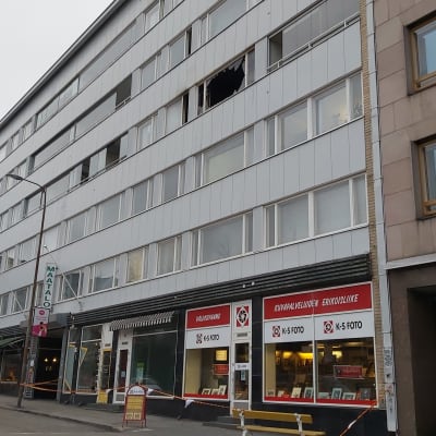 Kerrostalo, jonka ikkuna on mennyt rikki ja edusta rajattu huomionauhalla.