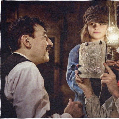 Albert, unga Louise och Edouard tittar på varandra i fotogenlampans sken.