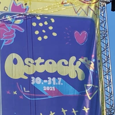 Qstockin 2021 mainosbanderolli päälavan vieressä.