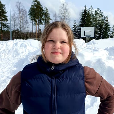 12-vuotias Fanni Poikola seisoo lumikinoksen edessä kädet puuskassa Isolahden koululla Muuramessa.