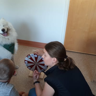 Talterapeut Jannica Lindholm övar med Liam Nordström och samojeden Yeti.