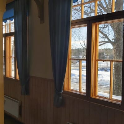 En vägg med fönster genom vilka man ser ett vinterlandskap.