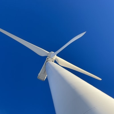 A wind power turbine viewed from below.