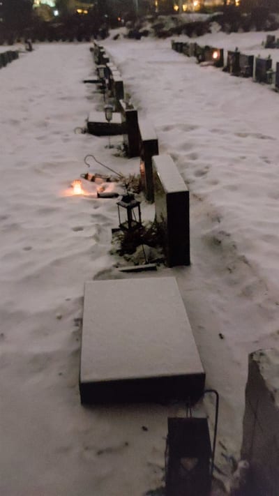 Gravstenar som fällts på en begravningsplats på vintern.