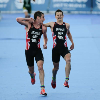 Alistair Brownlee hjälper brodern Jonathan över mållinjen i ett triathlonlopp i Mexiko.