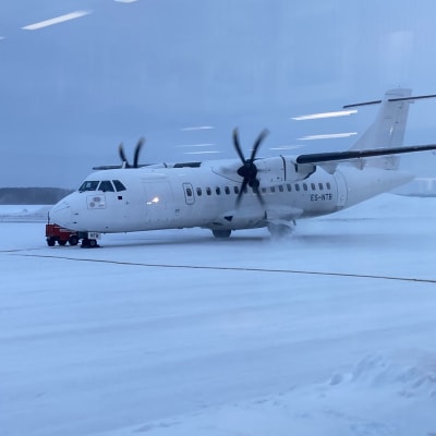 Pieni lentokone Savonlinnan lumisella lentokentällä aamuhämärässä. 