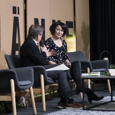Jenni Haukio kuuntelee haastattelijaa Jyväskylän kirjamessujen lavalla. 