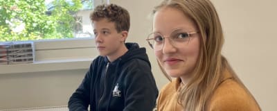 Två skolelever sitter vid ett fönsterbord i skolan.