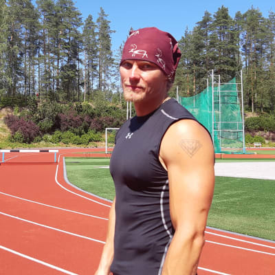 Matti Mononen seisoo yleisurheilukentälllä kesällä.
