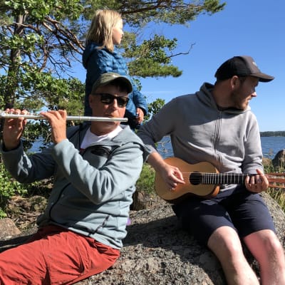 Pasi Hiihtola, Mikael Grönroos och Livs sitter på en strandsten