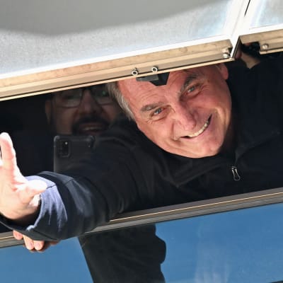 Jair Bolsonaro vinkar i ett fönster.
