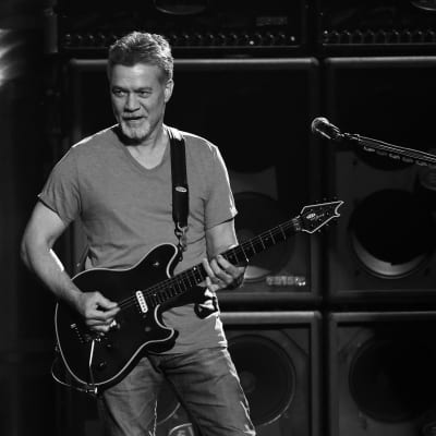 Gitarristen Eddie Van Halen spelar gitarr på en scen. Bilden är svartvit.