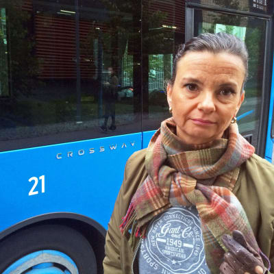 Allvarlig kvinna; Annamari Auermaa med HRT:s buss i bakgrunden.
