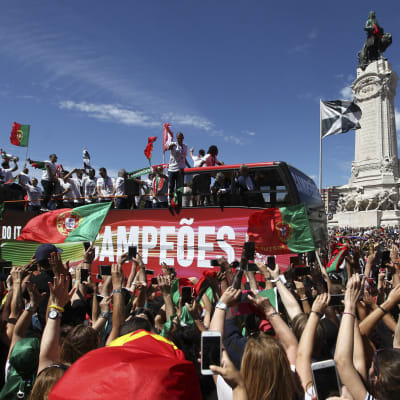 Portugals guldhjältar på ett bussflak i ett folkhav.