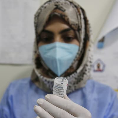Hoitaja valmistelee koronarokoteannosta Intian Kashmirissa