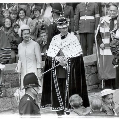 Kuningatar Elisabet II ja juuri kruunattu Walesin prinssi Charles tervehtimässä kadulle kerääntynyttä yleisöä Caernarfonin linnan edustalla Walesissa 1969.