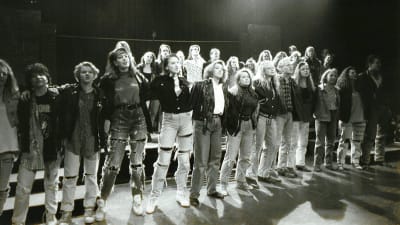 Ungdomar i en musikal står rad på scenen.