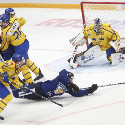 Jani Lajunen vräker sig mot mål i en ishockeymatch mellan Finland och Sverige.