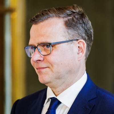En man i blå kostym småler.