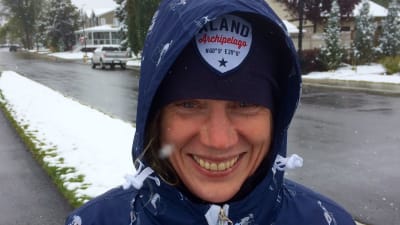 Susanne Österlund-Pötzsch är ute i ett lite snöigt bostadområde och har huvan uppfälld pås blåa jacka.