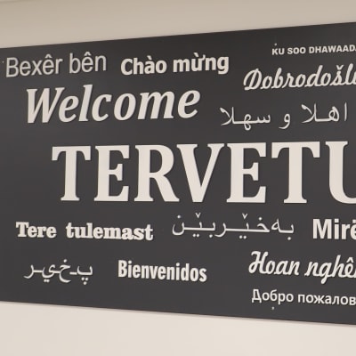 En skylt där ordet välkommen står på många olika språk.