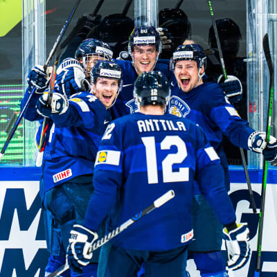 Fem finländska hockeyspelare jublar över ett mål.