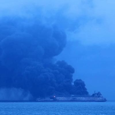 Tankfartyg brinner på havet utanför Shanghai. Tjock svart rök stiger från båten.