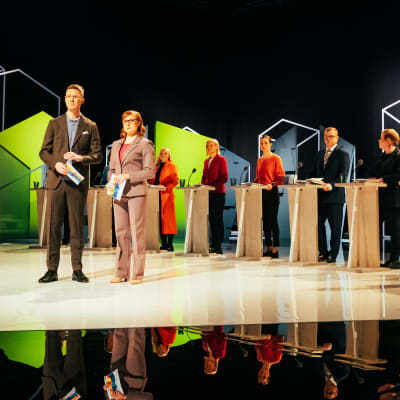 Juontajat ja puolueiden puheenjohtajat studiossa.