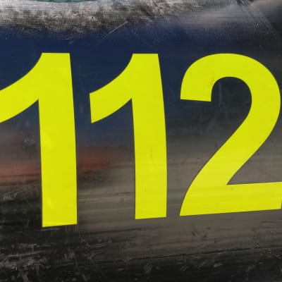Yleinen hätänumero 112 teipattuna pelastuslaitoksne mustan kumiveneen kylkeen. 