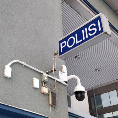 Poliisi-kylttu ja valvontakamera Jyväskylän poliisiaseman ulkoseinässä.