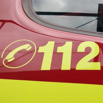 Närbild på räddningsfordon i rött och gult, på dörren syns nödnumret 112.