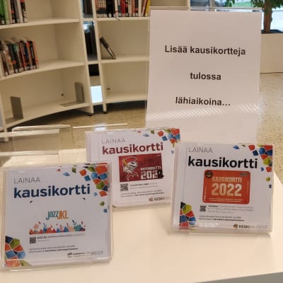 Jyväskylän kaupunginkirjastossa tarjolla lainattavaksi erilaisia kausikortteja. Kortteja hyllyn päällä. 