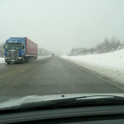Långtradare kör på snöig väg