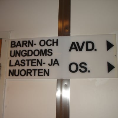 En skytl med texten "Barn- och ungdomsavdelning" på svenska och finska.
