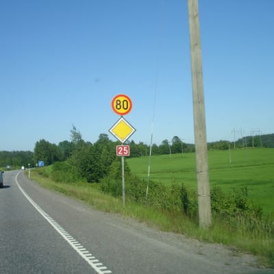 En bil kör på väg där skylten visar hastighetsbegränsning på 80 kilometer per timme.