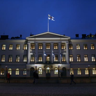 Presidentin linna iltavalaistuksessa, Suomen lippu katolla.
