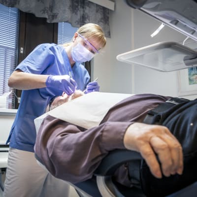 Tandläkare kollar tänderna på en patient