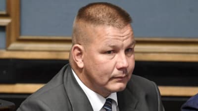 Riksdagsman Juha Mäenpää på sin plats i riksdagen.