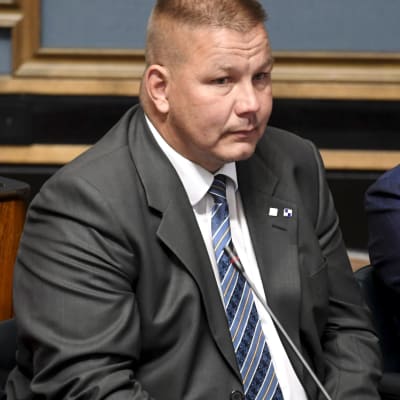 Riksdagsman Juha Mäenpää på sin plats i riksdagen.