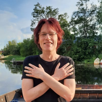 Kirjailija Jussi Seppänen seisoo laiturilla ja hymyilee.