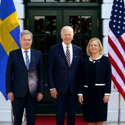 Sauli Niinistö, Joe Biden ja Magdalena Andersson seisovat oven edessä. Taustalla Yhdysvaltain, Suomen ja Ruotsin liput.